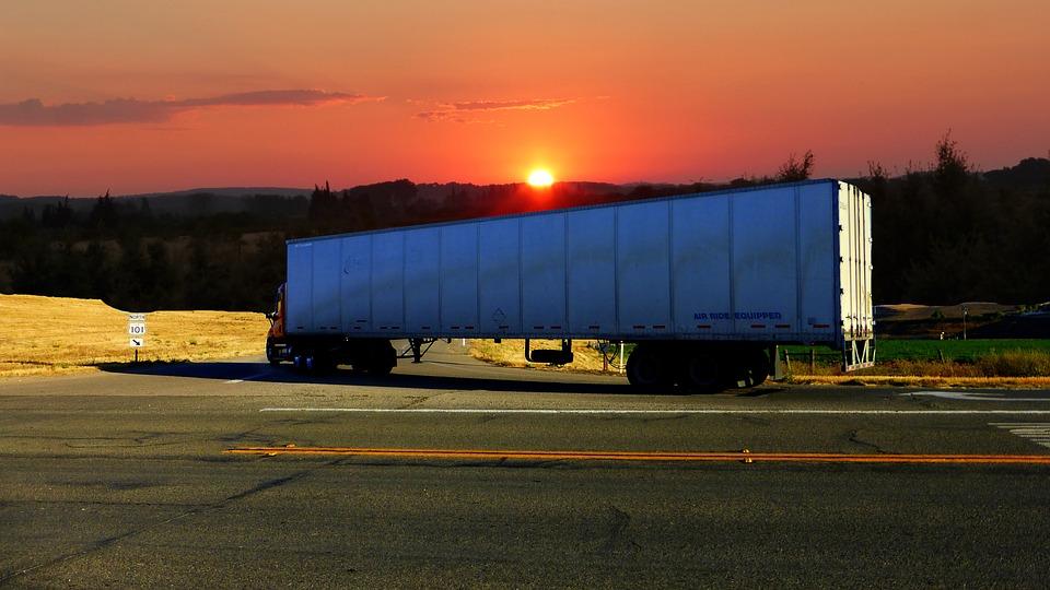 sunset behind hgv truck trailer